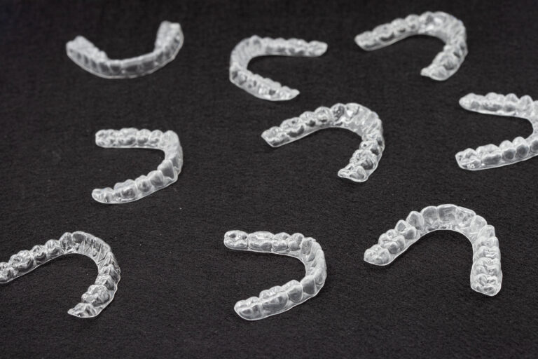 Transparent plastic mouth guard for teeth clenching. Grinding dental bite sleep aid. Dental care.