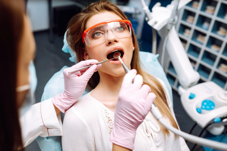 Young woman at the dentist's chair during a dental procedure. Overview of dental caries prevention. Healthy teeth and medicine concept.