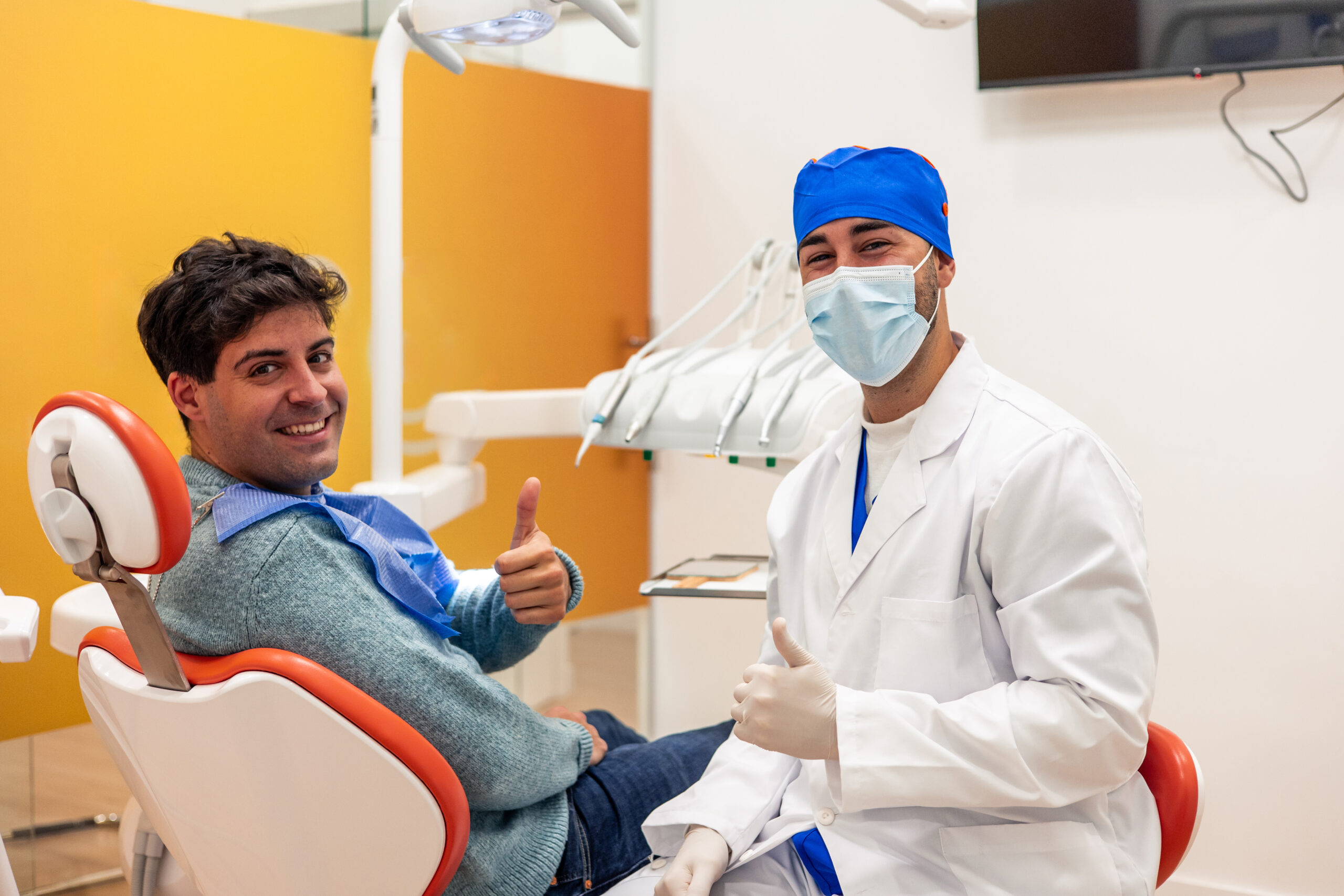 Happy dentist and patient showing thumbs up sign of satisfaction after a successful dental checkup in a modern dental clinic. Highlighting the importance of oral hygiene and professional dental care