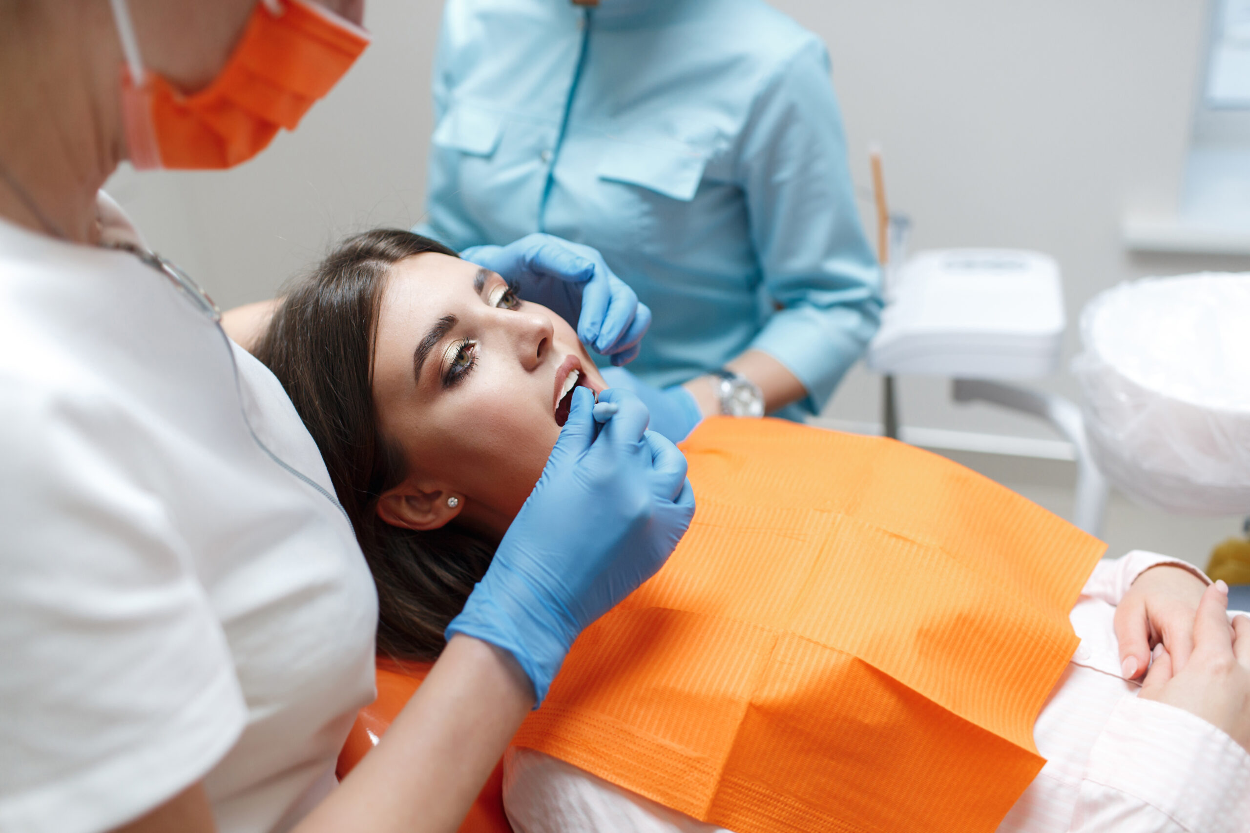 Dentist and assistant treat a patient's tooth.Doctor dentist treats teeth of a beautiful young girl patient. Doctor dentist treats tooth.Beautiful smile. The client in the dental chair.